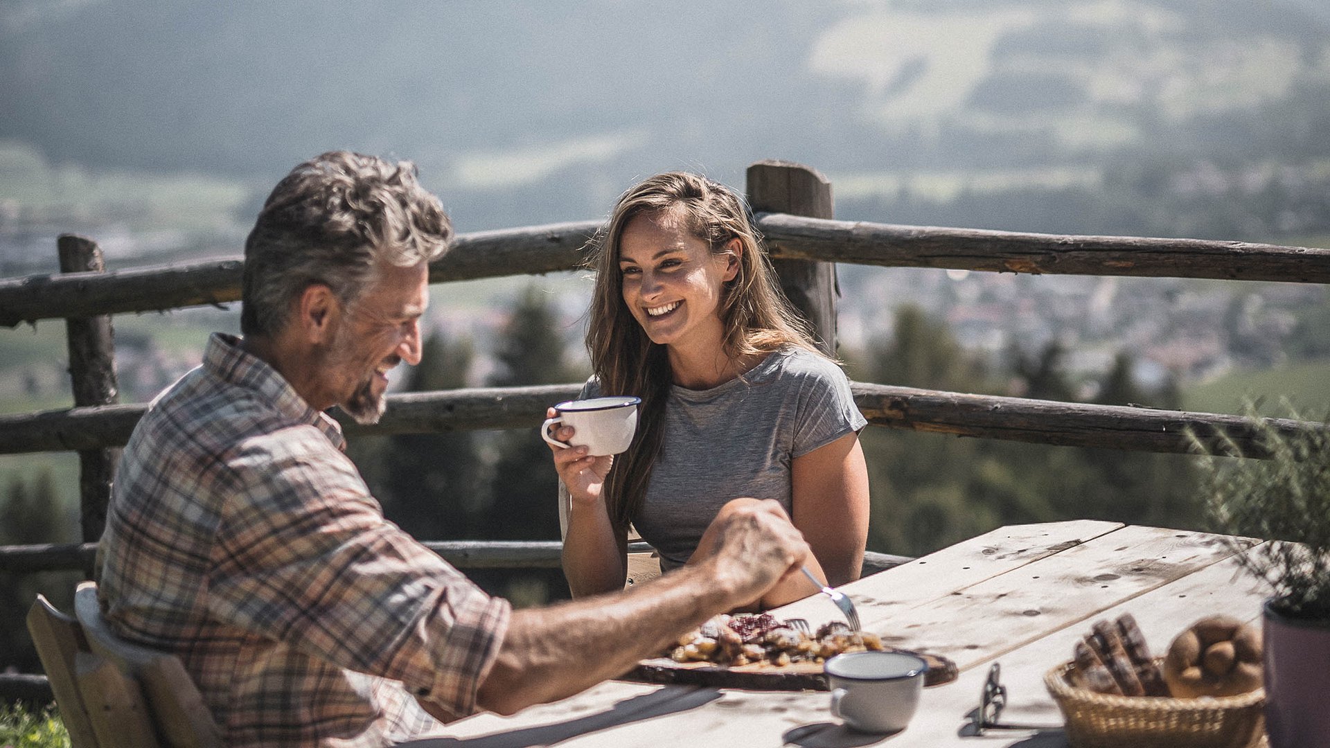 Vacanze in Alto Adige in estate: indimenticabili Due persone che prendono caffè e dolce all'aperto con vista montagna