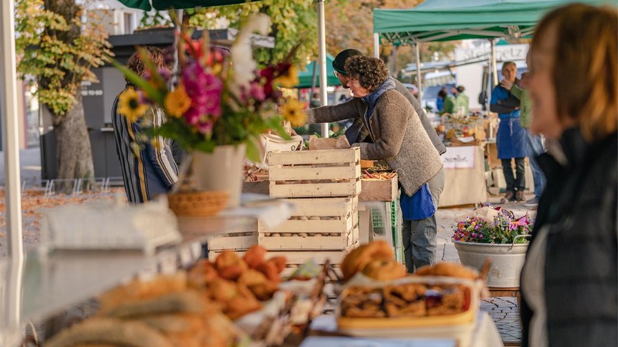 Ein Fest für die Sinne Menschen kaufen frisches Obst und Gebäck auf einem Markt mit grünen Sonnenschirmen