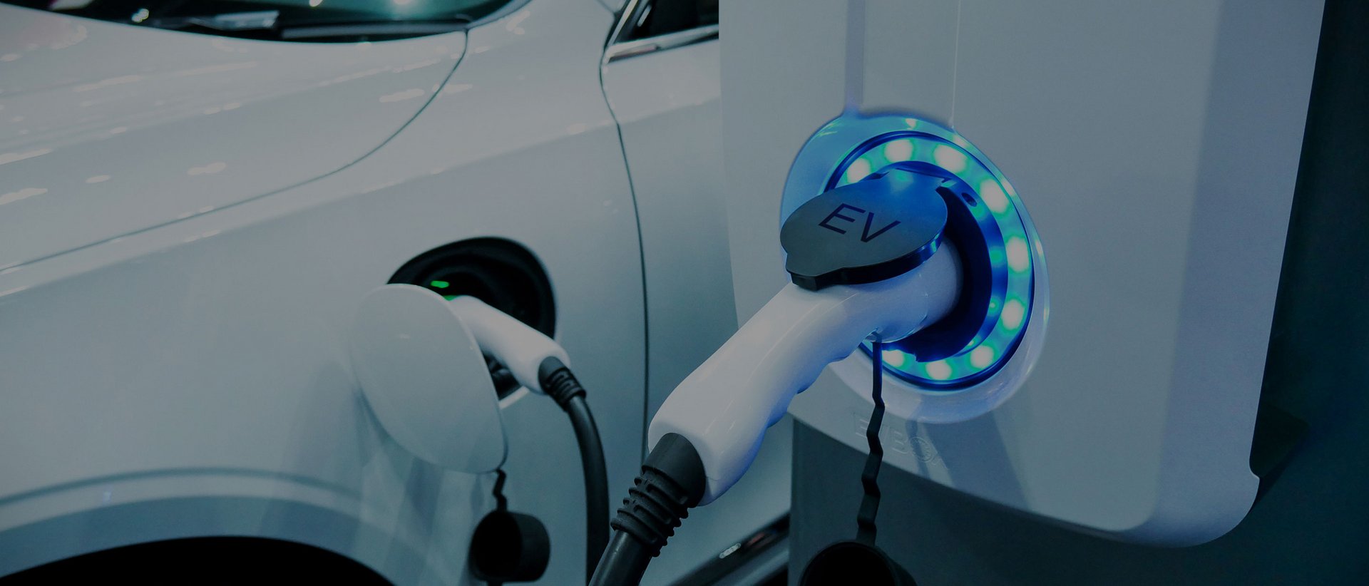 A holiday in the best location White electric vehicle charging at a station with blue illuminated plug