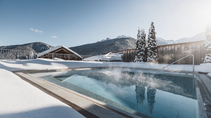 Un luogo di benessere, tranquillità ed energia rinnovata Piscina esterna riscaldata con vapore in resort di montagna innevato