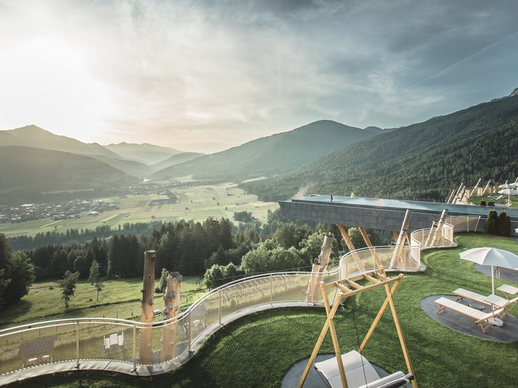 Shopping a Brunico e molto altro ancora Vista su terrazza con piscina e panorama alpino al tramonto