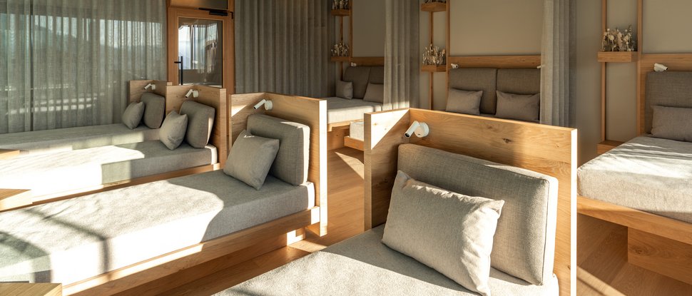 Our 5-star hotel in Italy between heaven and earth Modern relaxation room with comfortable loungers and wood decor in natural light