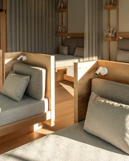 Our 5-star hotel in Italy between heaven and earth Modern relaxation room with comfortable loungers and wood decor in natural light