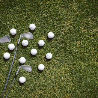 Golf Club Pustertal - Il tuo campo di golf a Plan de Corones Tre mazze da golf e molte palline da golf sull'erba