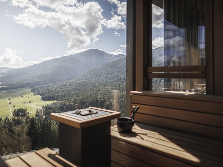 Our wellness hotel in Val Pusteria for relaxation seekers Sauna with panoramic view of forested mountains and valley