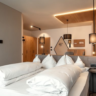 The Hubertus in a short time-lapse Modern hotel room with double bed and warm lighting fixtures