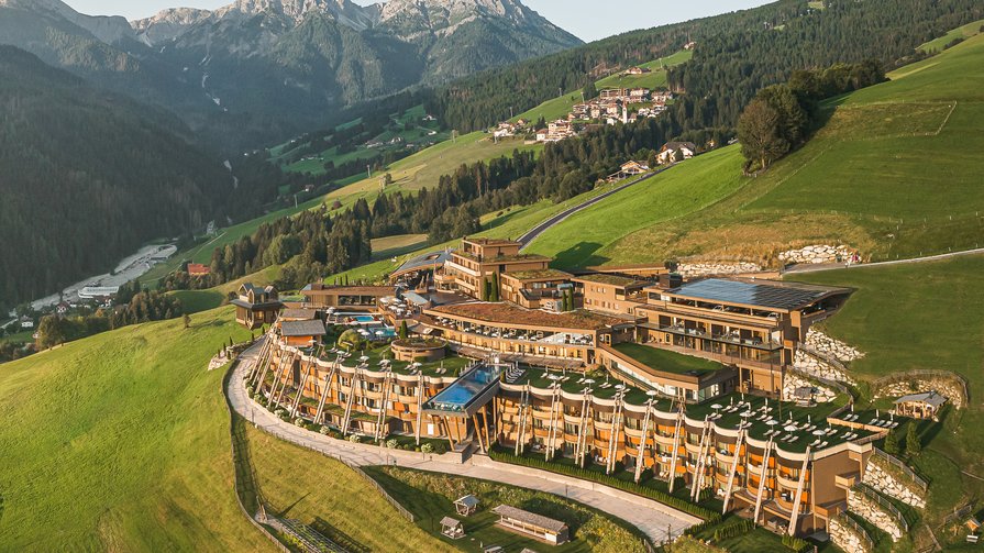 Entdecken Sie die Neuerungen Luxushotel in den grünen Alpen mit Bergen im Hintergrund