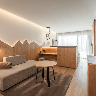 Current news and stories from Olang Modern hotel room with seating area and light wooden furniture