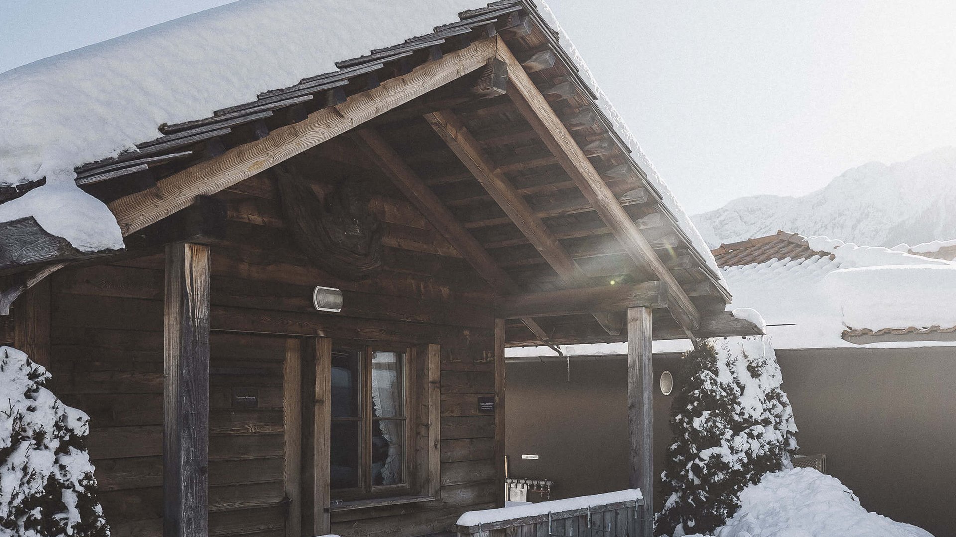 Our sauna, Plan de Corones/Kronplatz in full view Snow-covered wooden cabin with porch on a sunny winter day