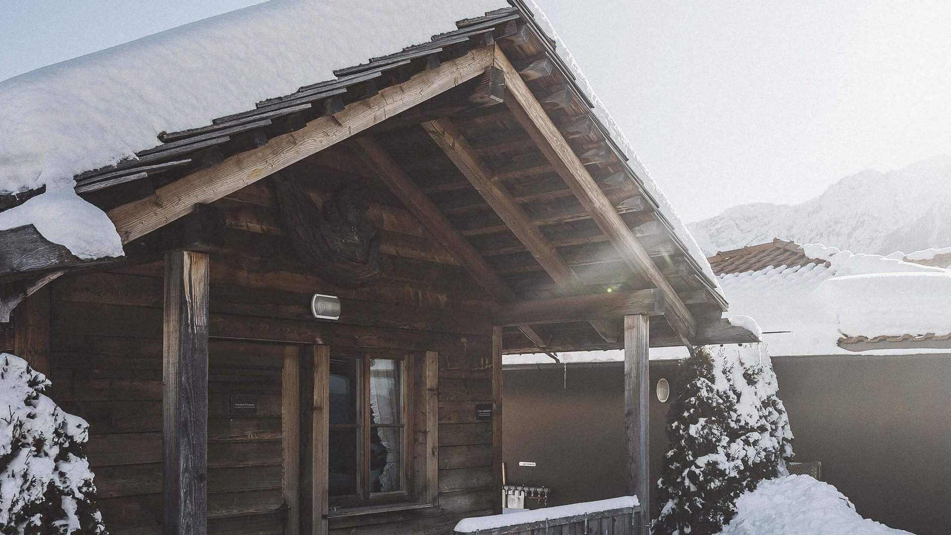 Unsere Sauna, den Kronplatz im Blickfeld Verschneite Holzhütte mit Terrasse an sonnigem Wintertag