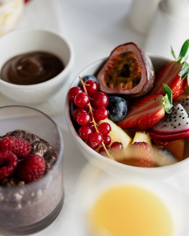 Aktuelle News und Geschichten aus Olang Schüssel mit frischem Obst, Chia-Pudding und Schokolade auf weißem Tisch