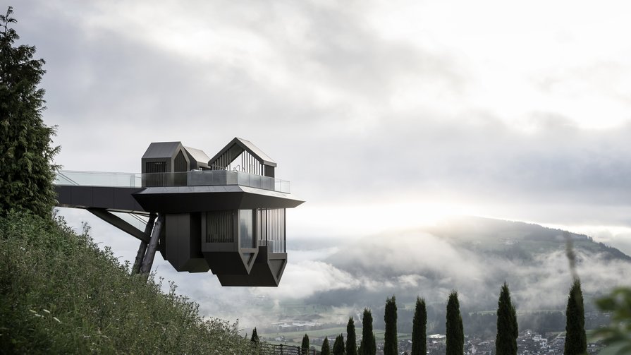 Innovation and Nature at Alpin Panorama Hotel Hubertus Modern viewing platform on stilts overlooking misty valley and mountains