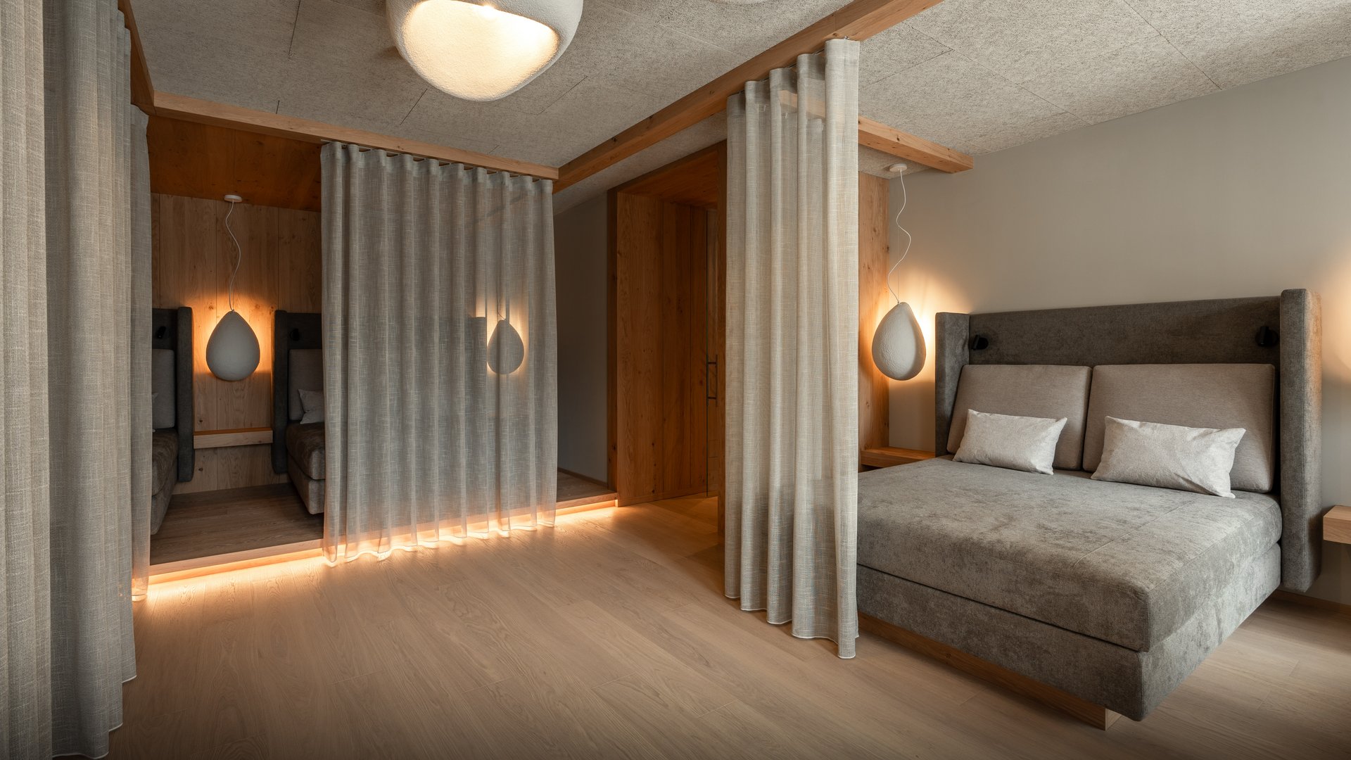 Le nostre saune in Val Pusteria vicino al Plan de Corones Camera da letto moderna con letto grigio, tende e luci soffuse