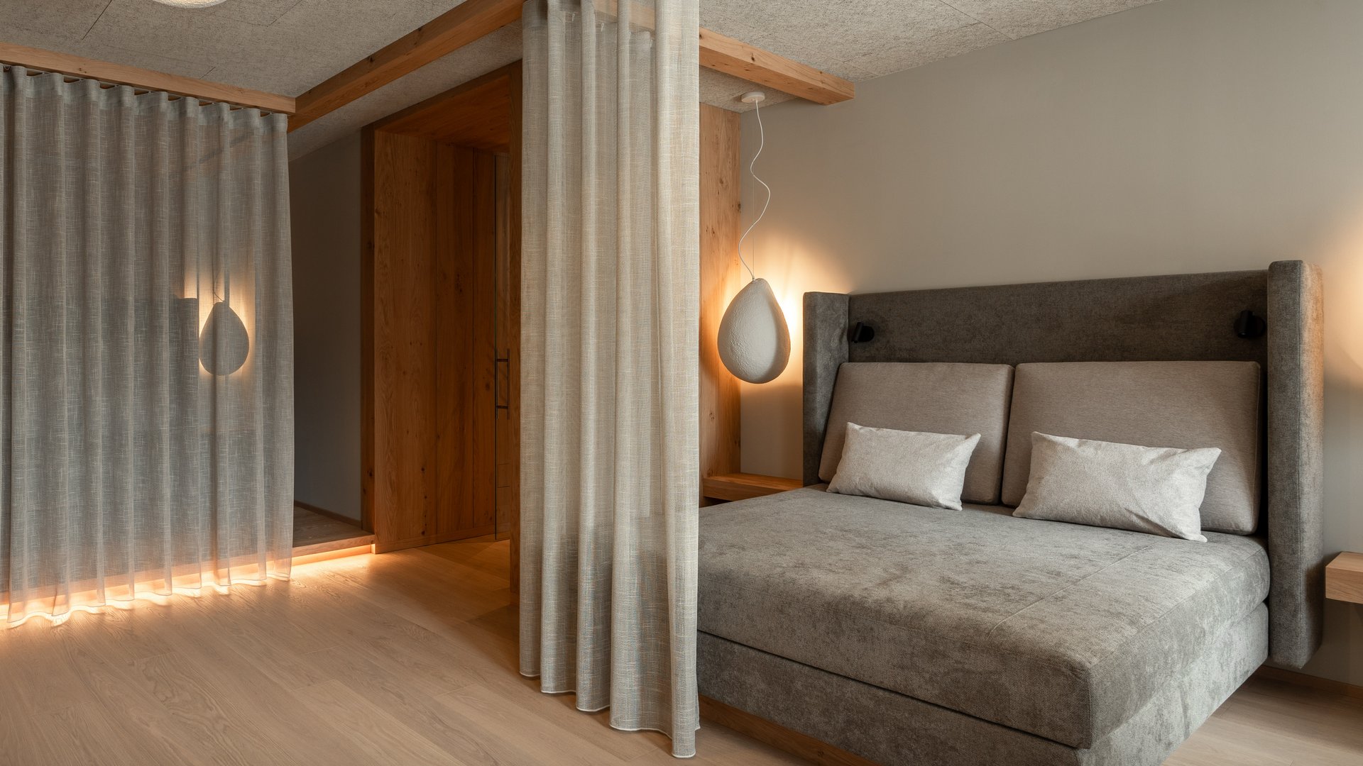 Unsere Sauna, den Kronplatz im Blickfeld Modernes Schlafzimmer mit grauem Bett, Vorhängen und weichen Lampen