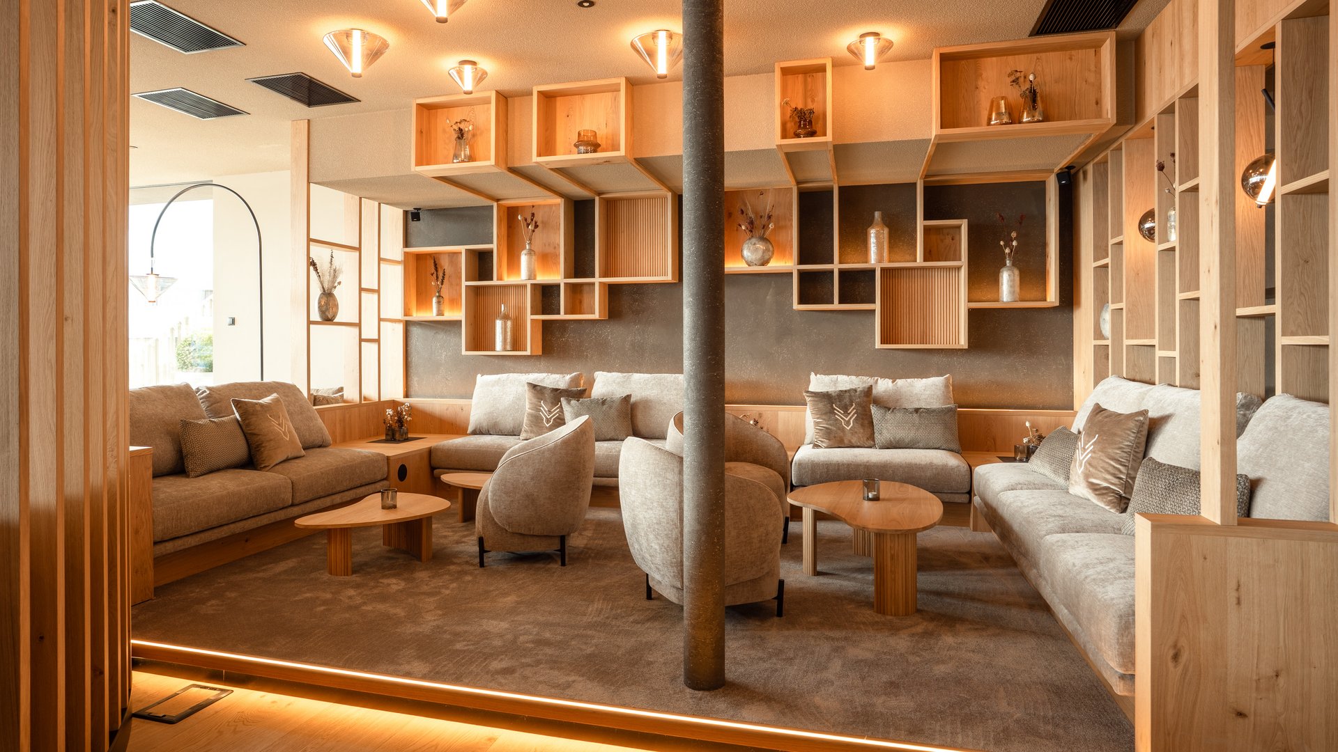 A place to enjoy Cozy lounge area with sofas, armchairs, and wooden wall shelves