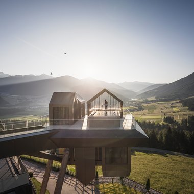 Awards & Press Moderne Aussichtsplattform mit zwei Hausstrukturen über Tal bei Sonnenuntergang