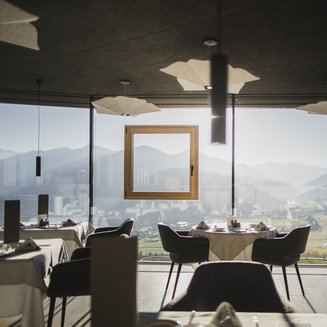 Shopping a Brunico e molto altro ancora Ristorante con vista panoramica sulle montagne e sulla valle alla luce del giorno