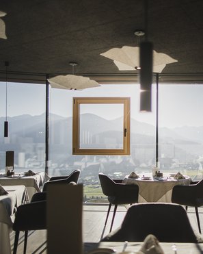 Unser Hotelgutschein: Südtirol im Geschenkformat Restaurant mit Panoramablick auf Berge und Tal bei Tageslicht