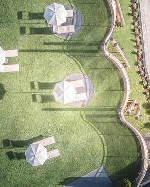 Unsere Parks, Ihre Rückzugsorte Luftaufnahme von Sonnenschirmen und Liegestühlen auf einem gepflegten Rasen