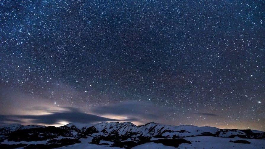 Entdecken Sie die Geheimnisse des Universums – direkt von unserer Hotelterrasse aus Sternklarer Nachthimmel über schneebedeckten Bergen