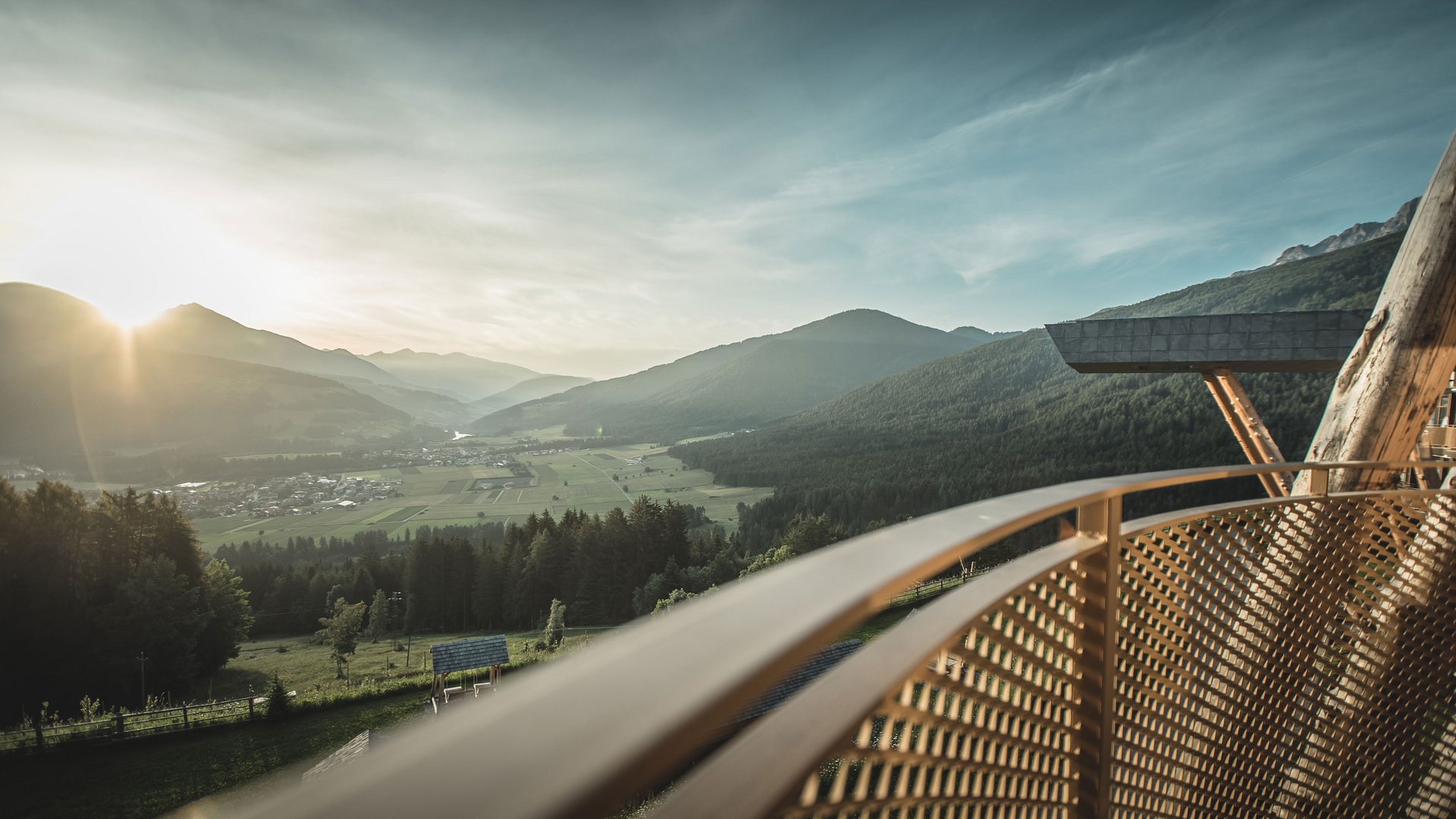 Mehr als Sauna im Pustertal: das Alpenreych Spa Sonnenuntergang über einem Tal mit Bergen und Blick vom Balkon mit Metallgeländer