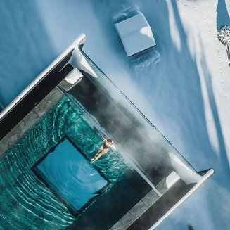 Bruneck: shopping & more Person swimming in heated pool surrounded by snow and winter landscape