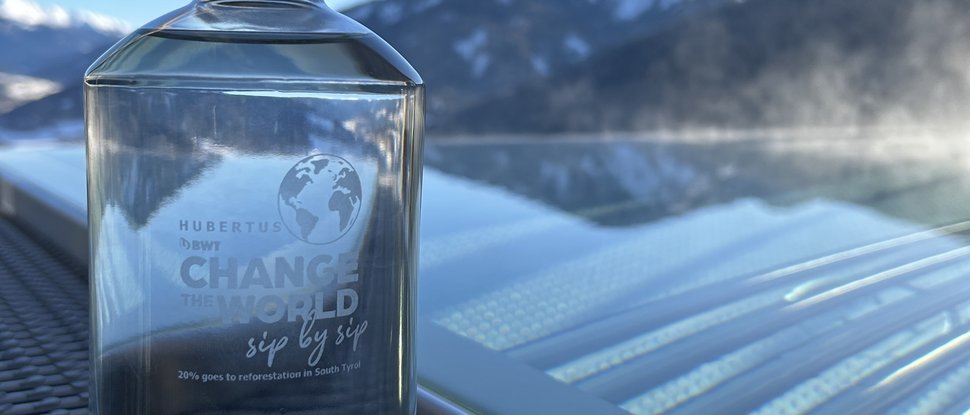 Ultime novità e storie da Valdaora Bottiglia di vetro trasparente con acqua davanti a paesaggio montano e cielo azzurro