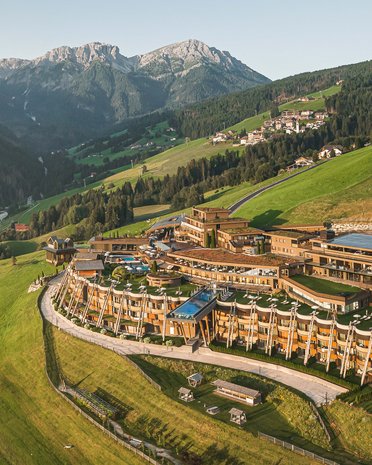 Ultime novità e storie da Valdaora Hotel di lusso su prato verde con montagne alpine sullo sfondo