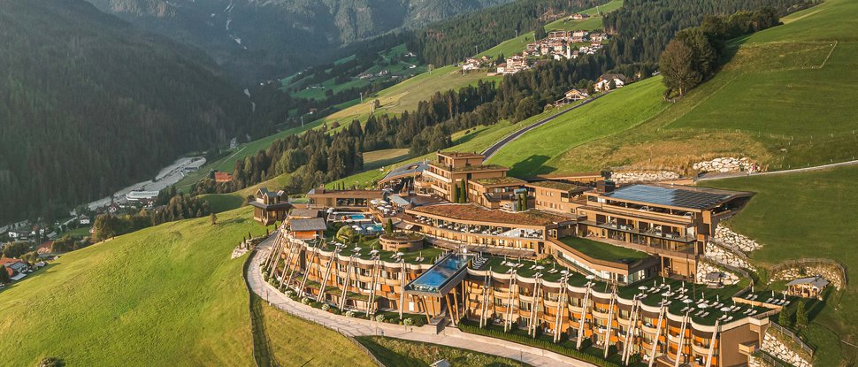 Ultime novità e storie da Valdaora Hotel di lusso su prato verde con montagne alpine sullo sfondo
