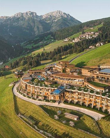 Current news and stories from Olang Luxury hotel on green hillside with Alpine mountains in the background