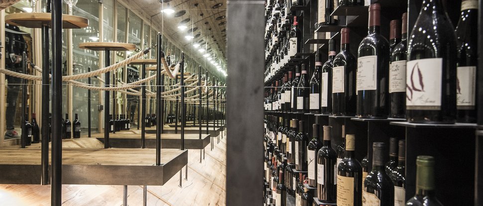 Current news and stories from Olang Wine cellar with many wine bottles and wooden panels