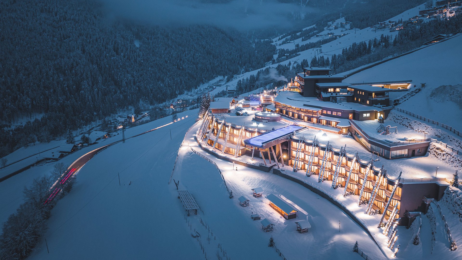 Gesunder Rücken in nur 5 Minuten Beleuchtetes modernes Berghotel im verschneiten Tal bei Nacht
