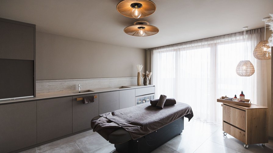 Tiefenentspannung erleben Moderner Massageraum mit Liege und gedämpfter Beleuchtung