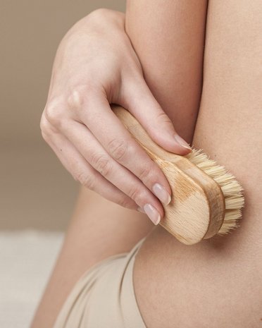 Current news and stories from Olang Hand holding dry brush exfoliating skin on body