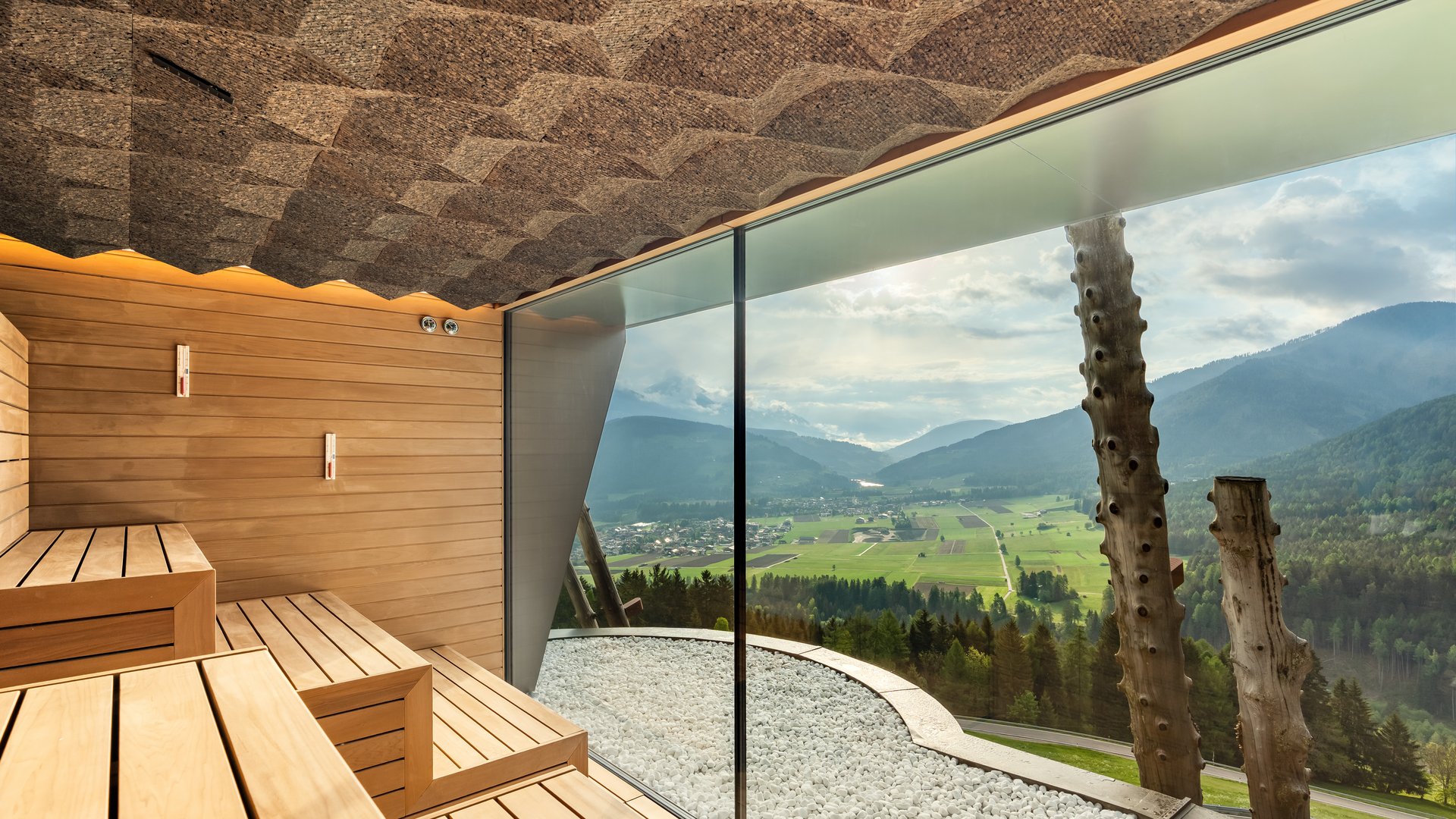 Our sauna, Plan de Corones/Kronplatz in full view Interior of a sauna with wooden bench and mountain view through glass wall