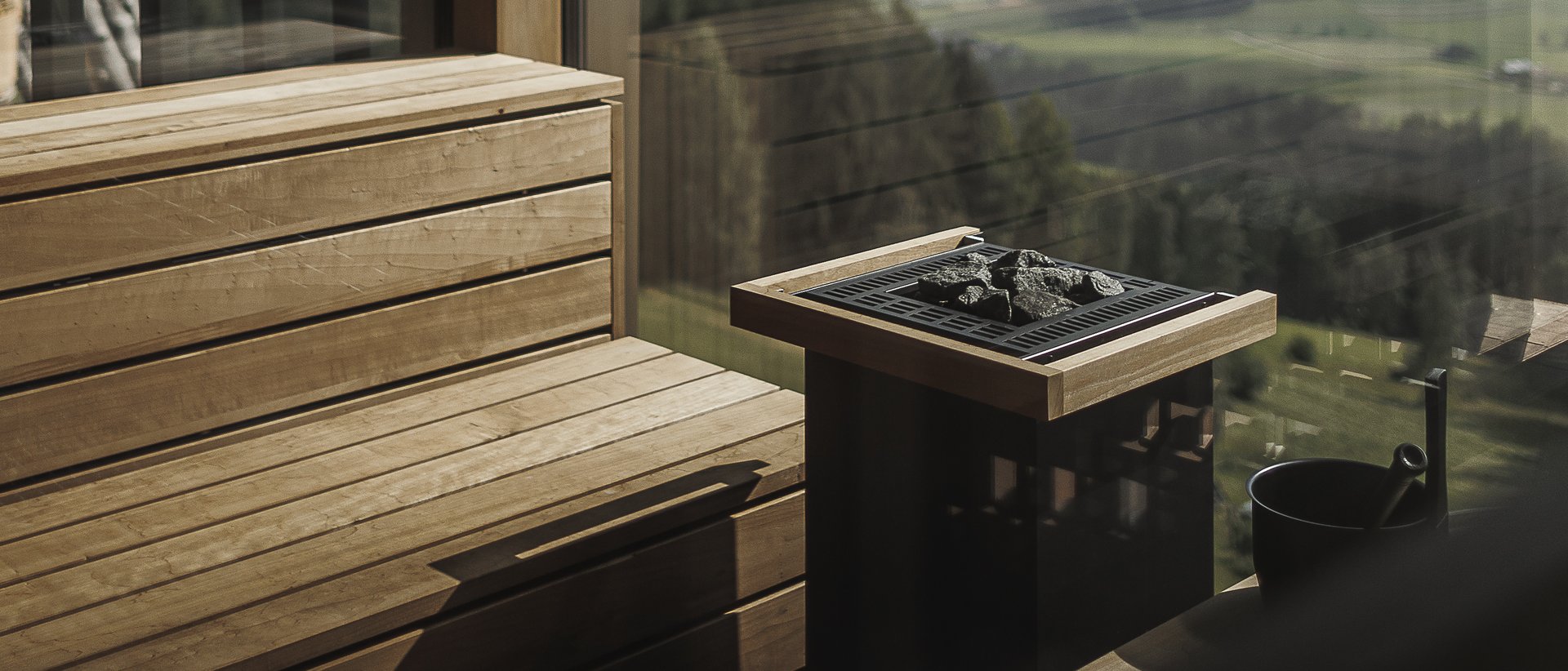 Our wellness hotel in Val Pusteria for relaxation seekers Sauna with wooden benches and panoramic view of mountains and valley