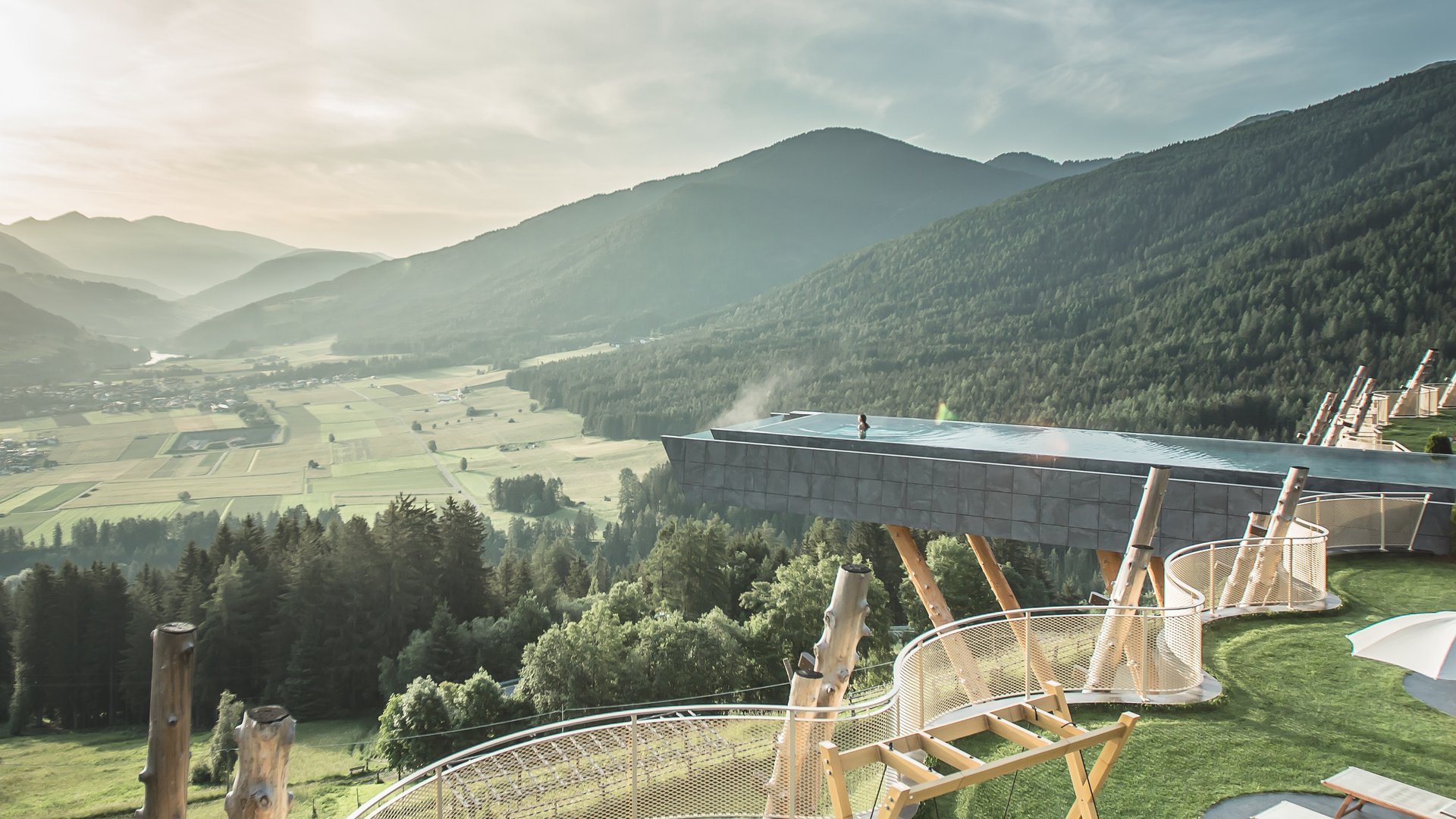 Unser Sky Pool in Südtirol, ein Prachtexemplar Sonnige Terrasse mit Liegestühlen, Schaukeln und Bergblick im Tal