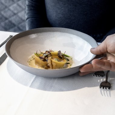 A holiday in the best location Woman being served plate with fine pasta and mushrooms at restaurant