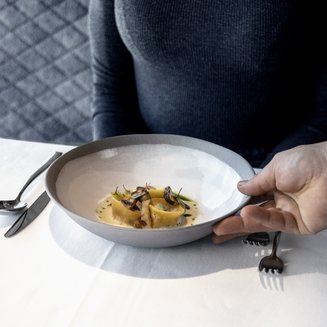 Experience moments of culinary magic Woman being served plate with fine pasta and mushrooms at restaurant