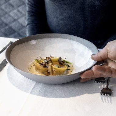 Unser Wochenprogramm im Sommer Frau erhält Teller mit feiner Pasta und Pilzen im Restaurant