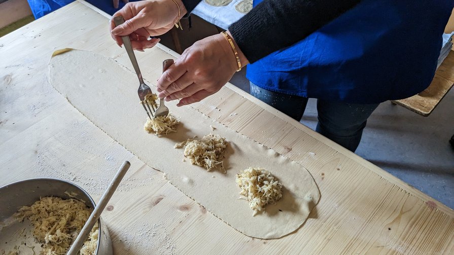 Cucina tradizionale altoatesina Persona mette ripieno su pasta stesa in cucina