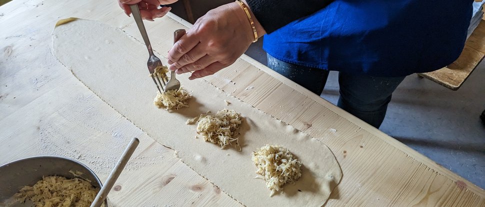 Current news and stories from Olang Person placing filling on rolled out dough in kitchen
