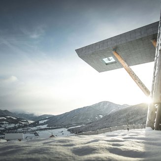 Bruneck: shopping & more Snowy mountains with modern building and sunlight in the valley